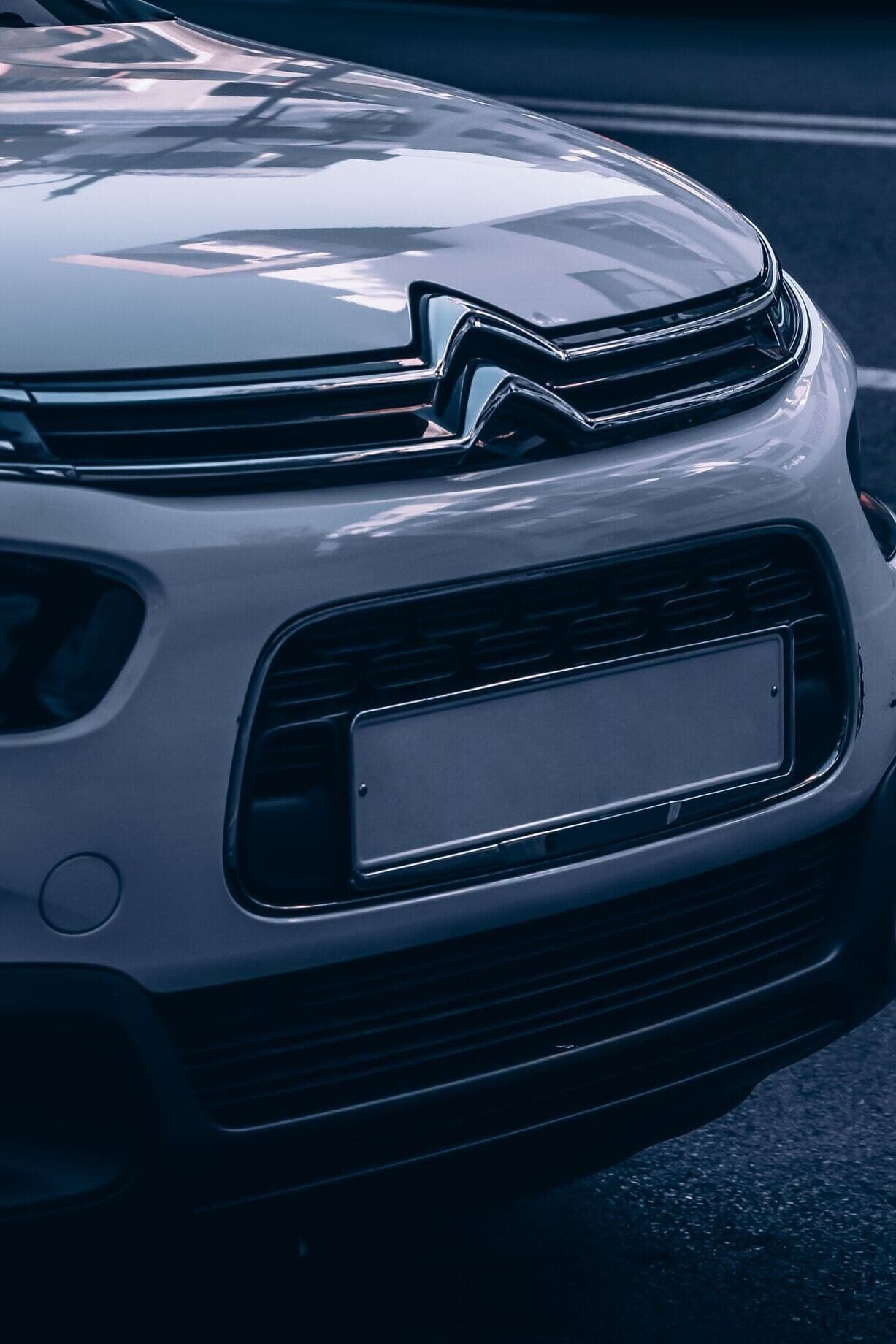 Front of a white Citroën C3 parked on a city street